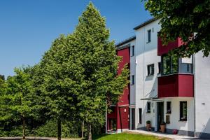 a tree in front of a red and white building at Gästehaus Turmblick in Bad Abbach