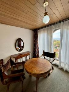 a dining room with a table and chairs and a window at Hotel Puntalarga PGB in Nobsa
