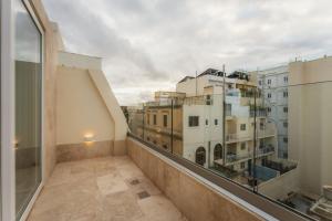 a balcony with a view of some buildings at NEW - Only Suites Unit 6 - Modern 2-Bedroom apartment with common heated Jacuzzi by SF Homes in St. Julianʼs
