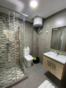 a bathroom with a shower and a toilet and a sink at Appartement OCEANICA RESIDENCES in Marina Smir