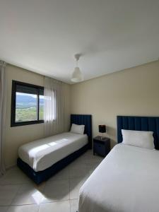 a bedroom with two beds and a window at Appartement OCEANICA RESIDENCES in Marina Smir