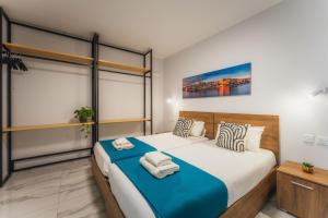 a bedroom with a large bed with a blue blanket at NEW - Only Suites Unit 6 - Modern 2-Bedroom apartment with common heated Jacuzzi by SF Homes in St. Julianʼs