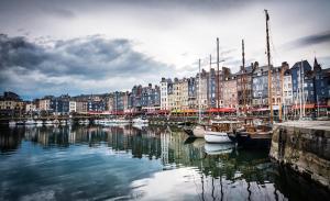a group of boats docked in a river with buildings at Les Maisons de Maje - Le Lingot in Honfleur