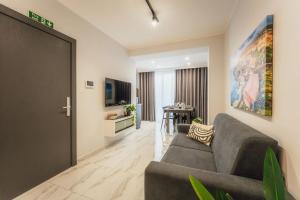 a living room with a couch and a table at NEW - Only Suites Unit 6 - Modern 2-Bedroom apartment with common heated Jacuzzi by SF Homes in St. Julianʼs