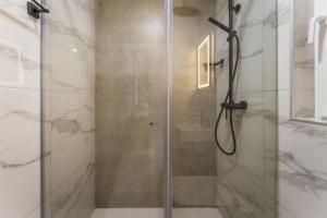 a shower with a glass door in a bathroom at NEW - Only Suites Unit 6 - Modern 2-Bedroom apartment with common heated Jacuzzi by SF Homes in St. Julianʼs +33 photos