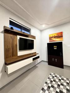a living room with a television on a wall at Casa Bairro Bosque com 3 quartos in Rio Branco