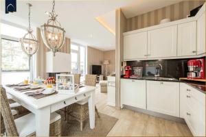a kitchen with white cabinets and a white table at Kapitänsweg 12 in Karlshagen