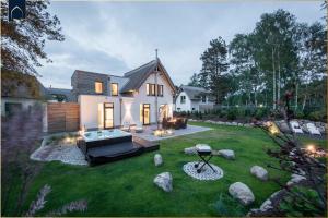 a house with a backyard with a hot tub in the yard at Kapitänsweg 12 in Karlshagen