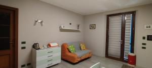 a living room with a chair and a dresser at Casa Rossy in Pieve San Giacomo