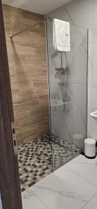 a shower with a glass door in a bathroom at Cabana Valea Lupilor in Straja