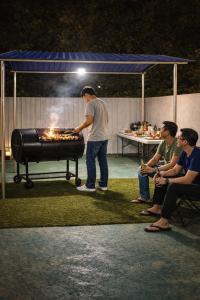 a man standing in front of a grill at night at Caca Kabin in Mersing