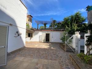 a white house with a gate and a courtyard at Al Castello - UN LETTO IDEALE in Gaeta