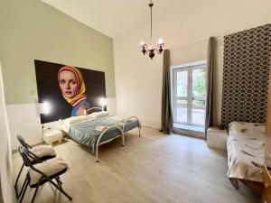 a room with a bed and a painting of a woman at Al Castello - UN LETTO IDEALE in Gaeta