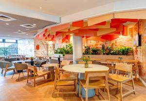 a restaurant with tables and chairs and plants at B&B HOME Rueil-Malmaison Gare in Rueil-Malmaison