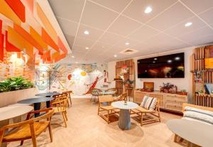 a restaurant with tables and chairs and a flat screen tv at B&B HOME Rueil-Malmaison Gare in Rueil-Malmaison