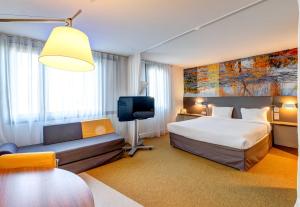 a hotel room with a bed and a couch at B&B HOME Rueil-Malmaison Gare in Rueil-Malmaison