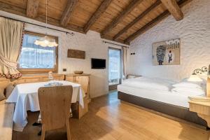 a bedroom with a bed and a table in it at Cësa Marmolada 1318 in Ortisei +68 photos
