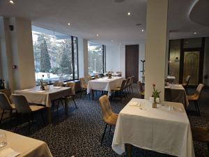 a dining room with white tables and chairs and windows at Best Western Silva Hotel in Sibiu
