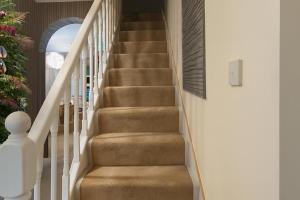 a staircase in a house with brown carpet at House-Sleeps 5 person -Etihad Stadium 15 min drive in Ashton under Lyne
