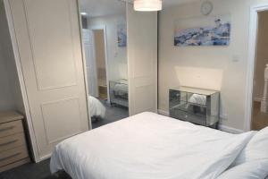 a bedroom with a white bed and a mirror at House-Sleeps 5 person -Etihad Stadium 15 min drive in Ashton under Lyne +5 photos