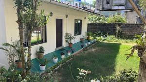 a garden with potted plants and a house at Meis cottage Umpling in Shillong