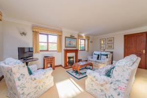 a living room with two chairs and a fireplace at Willow Cottage in North Lydbury