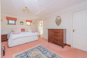 a bedroom with a bed and a dresser and a mirror at Willow Cottage in North Lydbury