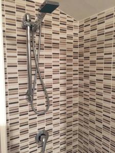 a shower in a bathroom with a tiled wall at Mansarda 13 in Salerno +27 photos