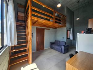 a living room with a loft bed and a couch at Residencial Zille - Lofts e Studios in São Miguel dʼOeste