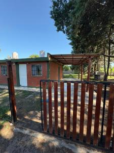 a wooden gate with a wooden canopy in front of a house at Las tres lunas in Villa Anizacate +3 photos