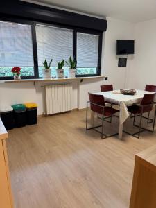 a room with a table and chairs and windows at Melannie's Apartment in Bergamo