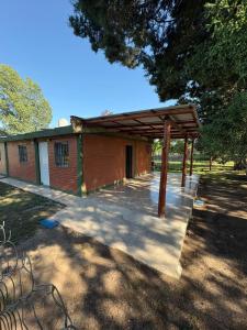 a building with a wooden pavilion in a park at Las tres lunas in Villa Anizacate