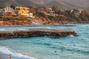 a beach with buildings and people in the water at Row 7 Holiday Homes in Kyrenia