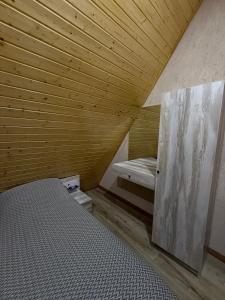 a small room with a bed and a wooden ceiling at A-frame , Quba Qecres in Qǝçrǝş