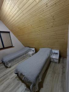 two beds in a room with a wooden ceiling at A-frame , Quba Qecres in Qǝçrǝş