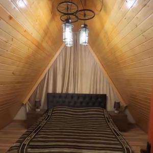 a bed in a room with a wooden ceiling at A-frame , Quba Qecres in Qǝçrǝş