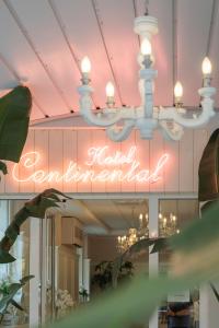 a chandelier with a neon sign in a store at Hotel Continental in Pietra Ligure