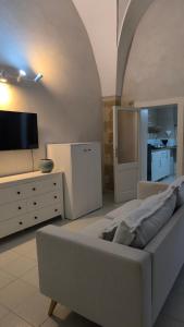 a living room with a large bed and a flat screen tv at Celebes in Brindisi