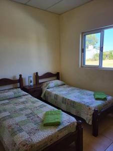 two beds in a room with a window at Chacra MARIANA in Gualeguay