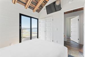a bedroom with a bed and a flat screen tv at Bodega Bay - Ocean View, Fireplace & BBQ in Bodega Bay