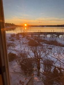 a view from a window of a snowy field with the sunset at Pet friendly waterfront condo in Edgecomb +11 photos