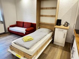 ein kleines Zimmer mit einem Bett und einer Couch in der Unterkunft Ferienapartments Zwingenberg in Zwingenberg