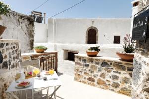 a patio with a table and chairs on a building at Mirthia Apartments in Myrthios