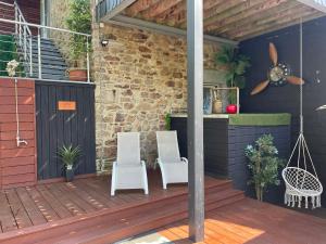 two white chairs sitting on a wooden deck at La Suite Diamant in Theux