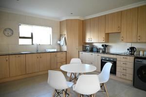 a kitchen with a white table and white chairs at Ongersfontein gasteplaas in Richmond