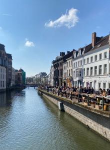 a group of people sitting on a bridge over a river at Schopenhauer in Ghent