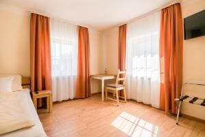 a bedroom with a bed and a desk and a window at WG-Pension in Landshut