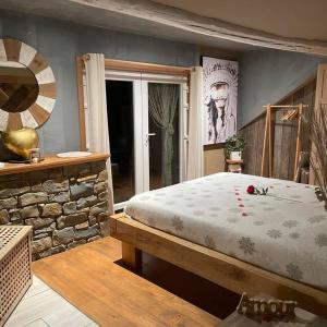a bedroom with a large bed and a stone wall at La Suite Diamant in Theux +42 photos