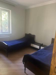 a bedroom with two beds and a window at mtatsminda residence in Itʼkhvisi