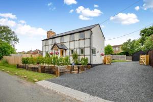 an exterior view of a white house with a garden at 3 Bed in Alfrick oc-s32386 in Broadwas